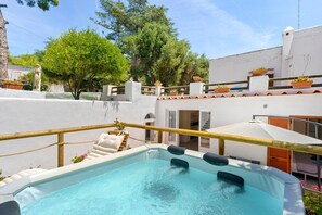 A rooftop pool with a hot tub, surrounded by potted plants and a white building. - Holiday Home 'Casa Gio e Angy' with Sea View, Wi-Fi & Air Conditioning (Forio)