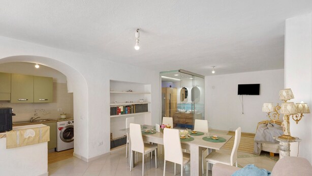 A modern kitchen with a washing machine, a dining area with a table and chairs, and a living space with a sofa. - Holiday Home 'Casa Gio e Angy' with Sea View, Wi-Fi & Air Conditioning (Forio)