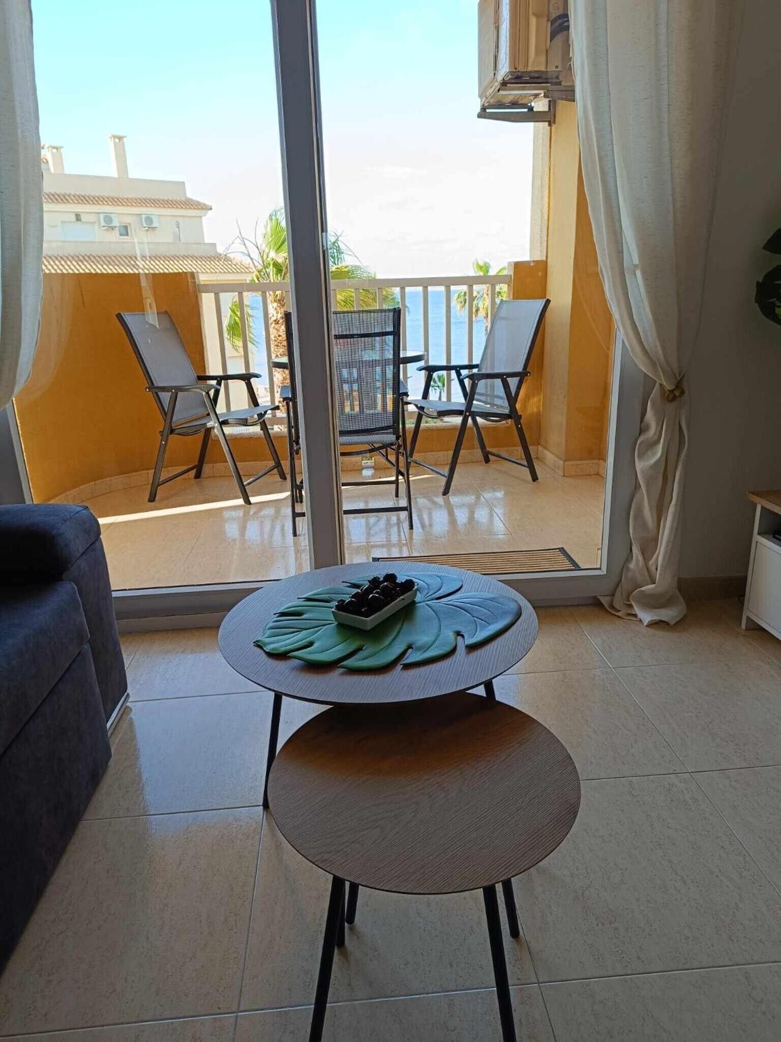 Ein Balkon mit Tisch für Zwei, einer Couch und Blick auf das Meer.