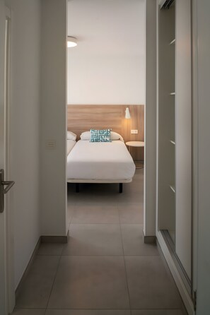 Ein Hotelzimmer mit Bett, Nachttisch und Lampe.