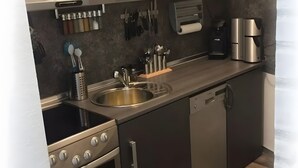 Una cucina compatta con lavello, fornelli e lavastoviglie.