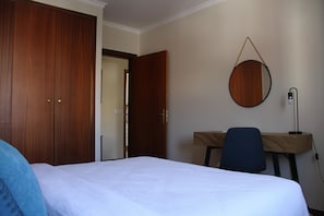 A bedroom with a bed, a desk, a chair, and a wardrobe. - Apartment 'Palma's Place' with Mountain View, Shared Garden and Wi-Fi (Caniço)