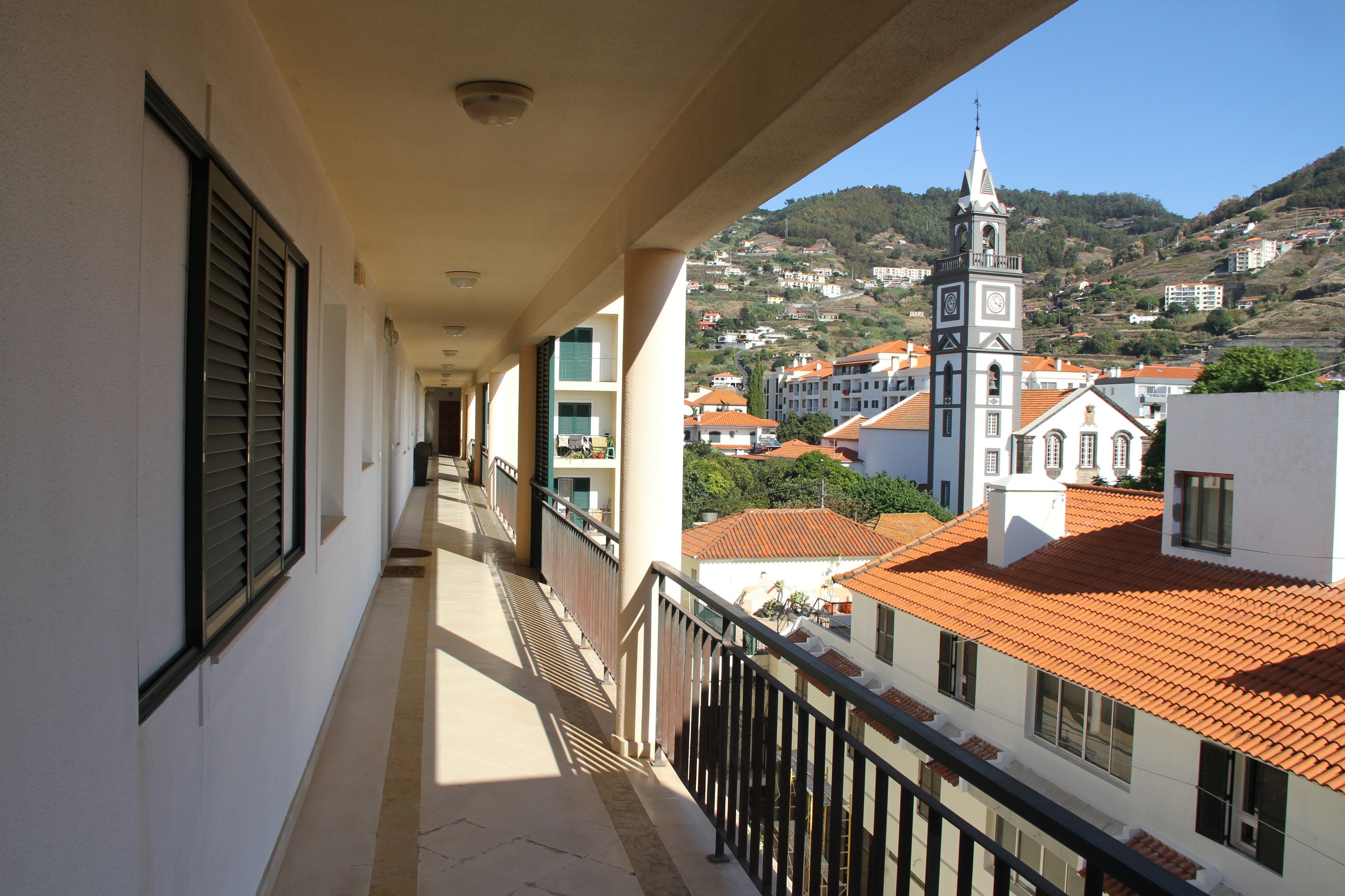 A balcony with a view of a town and a church.
