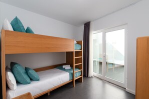 A bunk bed room with a wooden headboard, teal pillows, and a white mattress. - Villa 'Ereza Villas Royal Family Hoopoe 118' with Mountain View, Wi-Fi and Air Conditioning (Playa Blanca)