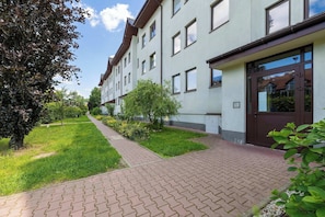 A multi-story building with a brick pathway leading to the entrance. - Turquoise Apartment | Large Terrace (Kraków)