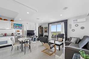 A modern living space with a kitchen, dining area, and seating area.