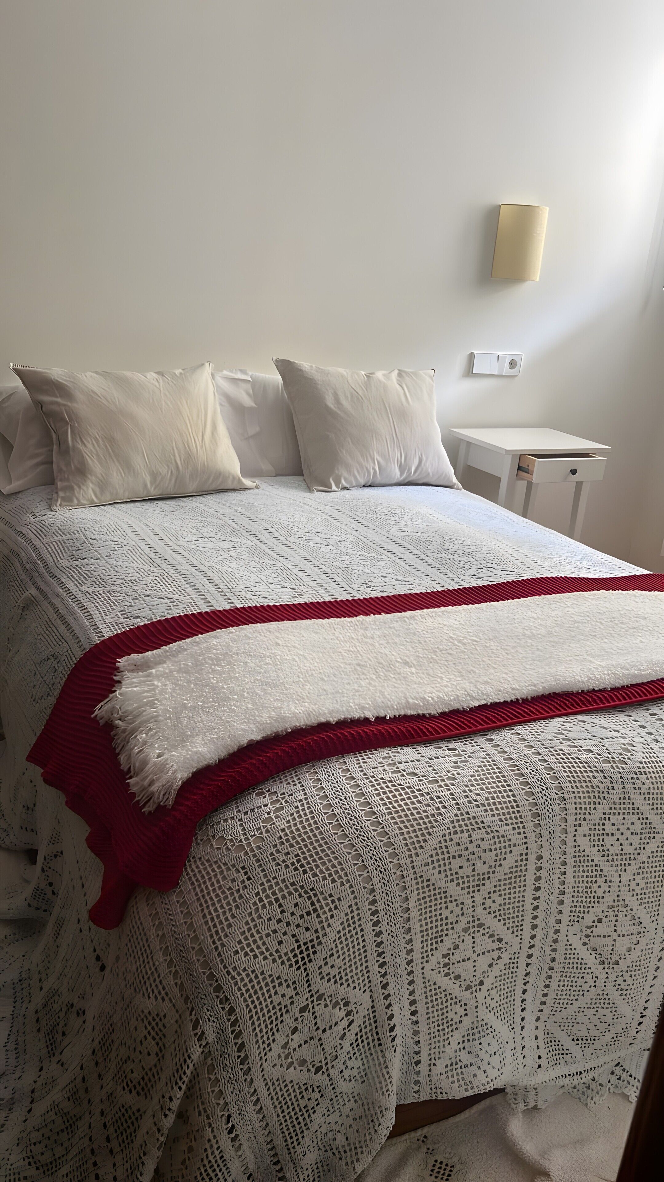 Tabla de planchar con plancha y ropa de cama