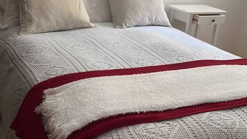 Tabla de planchar con plancha y ropa de cama