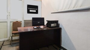 A corner office with a desk, computer, and printer, a chair, and a sign indicating it's a company-serviced townhouse. - Super Deluxe Room Townhouse Alwal Rd (Hyderabad)