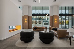 Ein modernes Interieur mit einer Couch, zwei Sesseln, einem Couchtisch und einem Bücherregal.