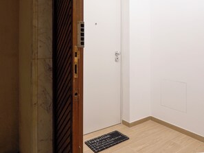 A closed door with a metal handle, a keyhole, and a peephole. - At Francesca's House - Balduina 88 (Roma)