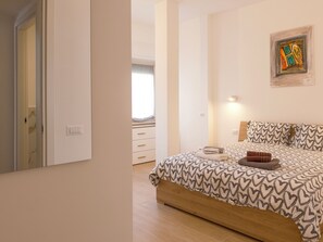 A bedroom with a bed, a bedside table, a wall-mounted painting, and a window. - At Francesca's House - Balduina 88 (Roma)