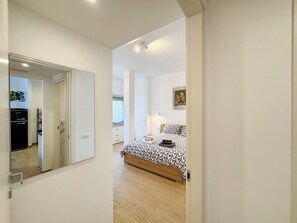 Un dormitorio con cama, mesita de noche y espejo.