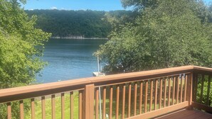 Une terrasse en bois offrant une vue sur un lac et une forêt.