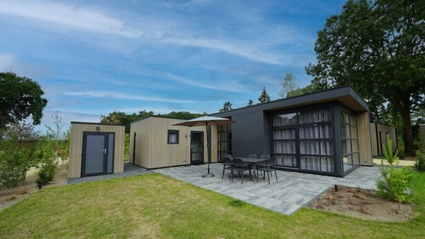 A modern house with a patio, a dining area, and a large window. - L-cube Hottub 4+2 (Maarn)
