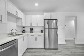 A modern kitchen with white cabinets, stainless steel appliances, and a dishwasher. - West Brickell #4 Free Parking & Renovated 2BR (Miami)