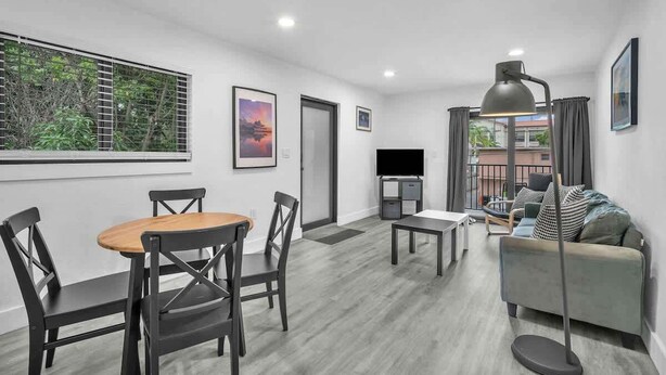 A modern living room with a dining table, chairs, a sofa, a TV, and a floor lamp. - West Brickell #3  Minutes to Downtown Miami (Miami)