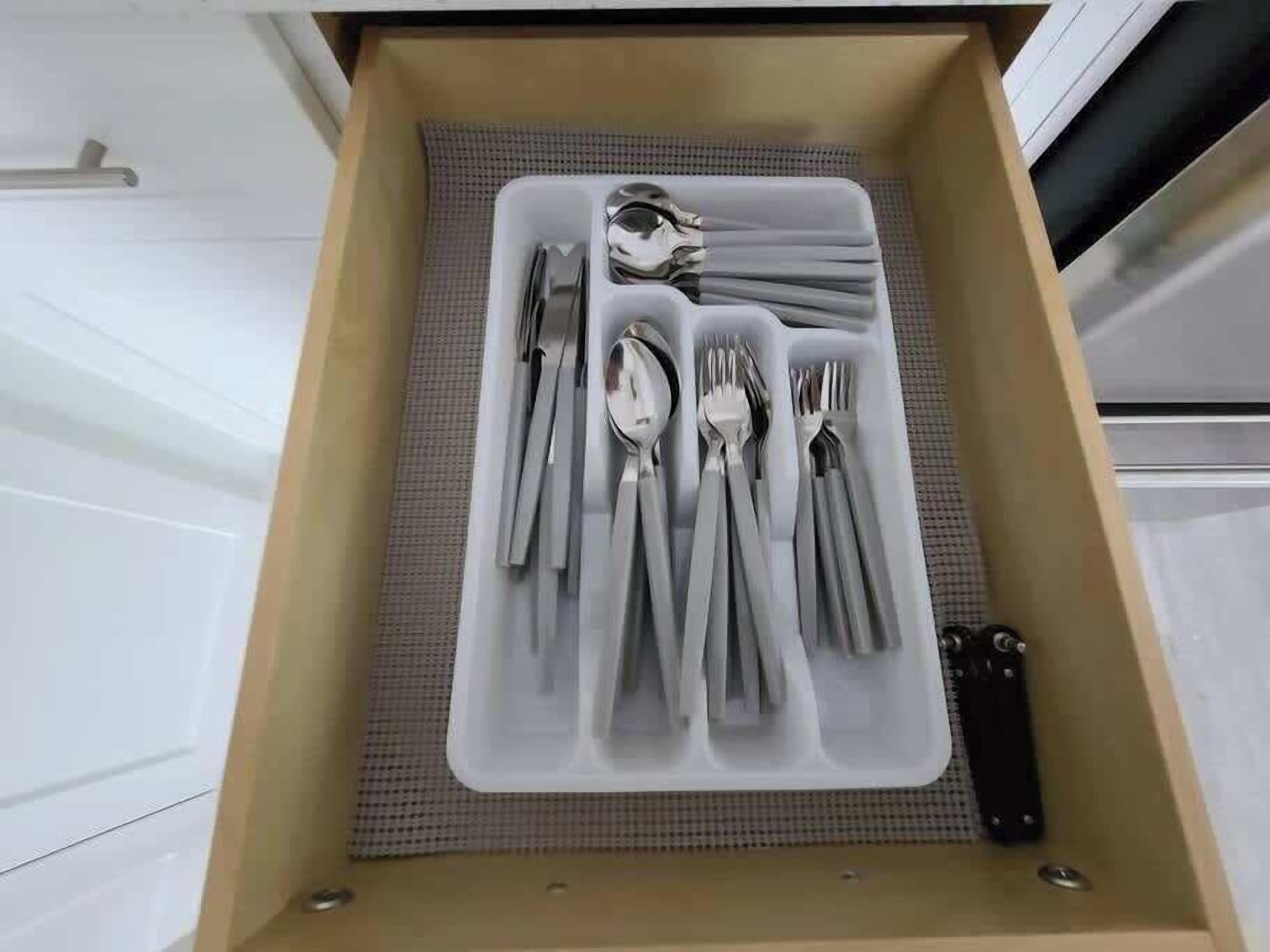 A drawer with neatly organized cutlery including forks, knives, and spoons.