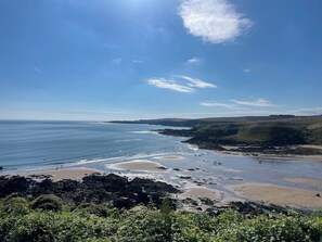 A coastal landscape with a beach, rocky shoreline, and greenery. - Beautiful House in Coastal Village (Coldingham)