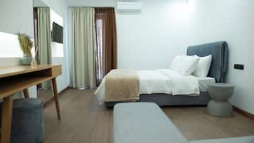 Deluxe Quadruple Room, Balcony | Desk, laptop workspace, blackout drapes, iron/ironing board