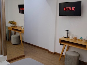 A hotel room with a wooden desk, a coffee maker, a mirror, and a wall-mounted TV displaying 'NETFLIX'. -  Klitiou 7 Boutique Hotel (Athens)