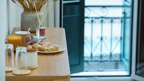Une table de petit-déjeuner avec un croissant, un verre de jus d’orange et une tasse de café.