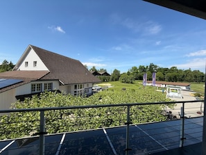 Een gebouw met een schuin dak, een zonnepaneel en uitzicht op een golfbaan.