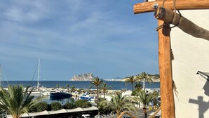 Ein Yachthafen mit Booten, Palmen und einer felsigen Küstenlinie.