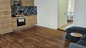 Eine moderne Küche mit Holzschränken, einer Marmor-Spritzschutzleiste und einer Pendelleuchte.