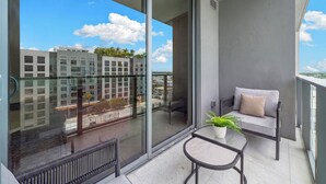 Een balkon met een bank, een kleine tafel en een bloempot.