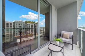 Ein Balkon mit einer Couch, einem kleinen Tisch und einem Blumentopf.