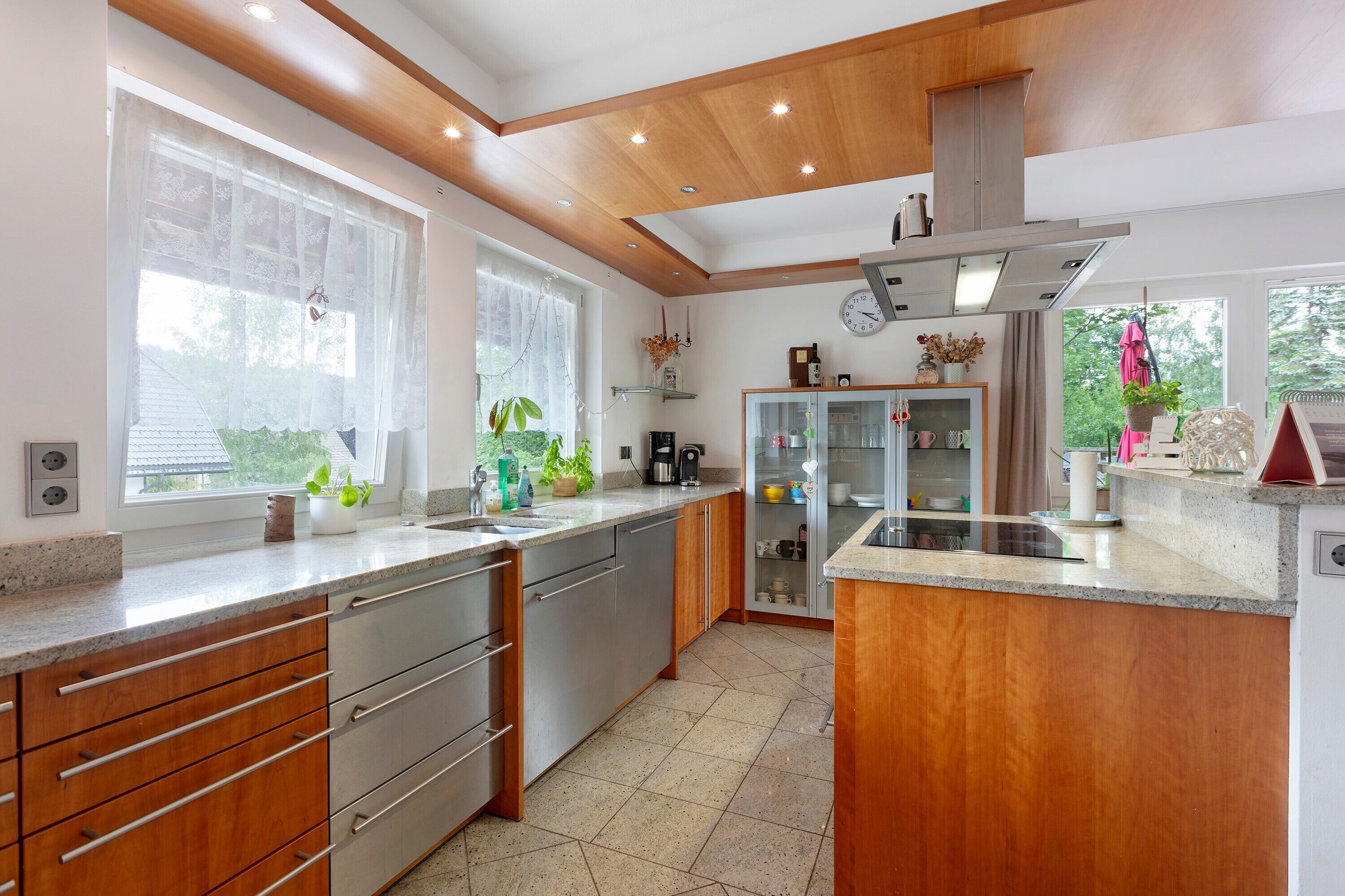 Una cocina moderna con armarios de madera, encimera de granito y horno empotrado.
