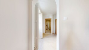 A hallway with a door leading to a bathroom.