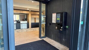 Un vestíbulo de hotel con recepción, zona de estar y diseño interior moderno.