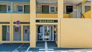 A B&B hotel with a sign, a no parking sign, a handicapped accessibility sign, and a double door entrance.