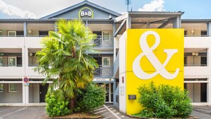 Un hôtel reconnaissable à son grand panneau jaune, à ses deux entrées et à son parking.
