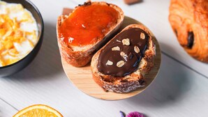 Deux pâtisseries sur une planche en bois, l’une fourrée à la confiture de fruits rouges et l’autre au chocolat et aux noix.