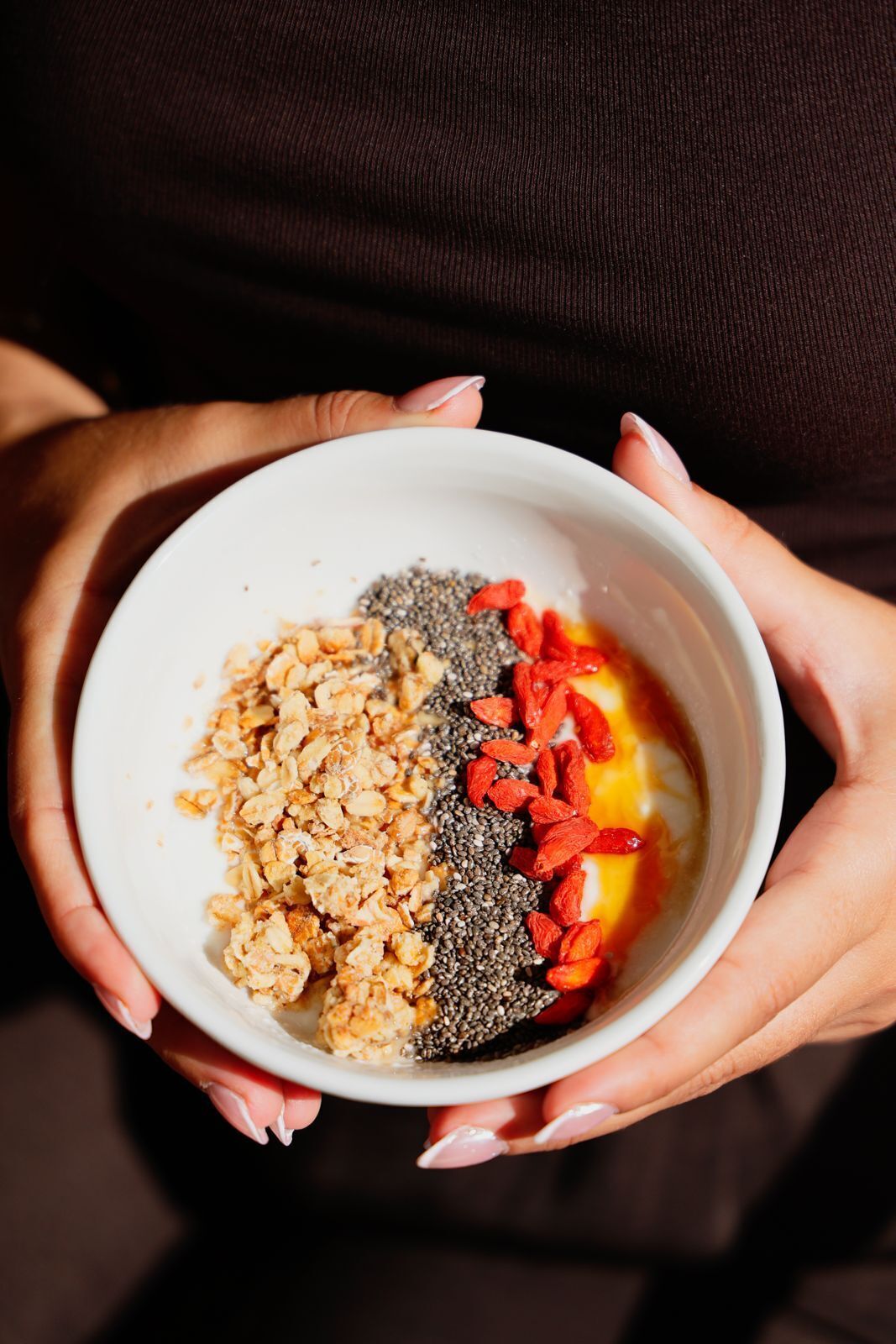 Un tazón de granola con semillas, semillas de chía y bayas rojas.
