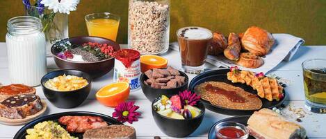 Ein reichhaltiges Frühstücksbuffet mit Speisen und Getränken auf einem Tisch.