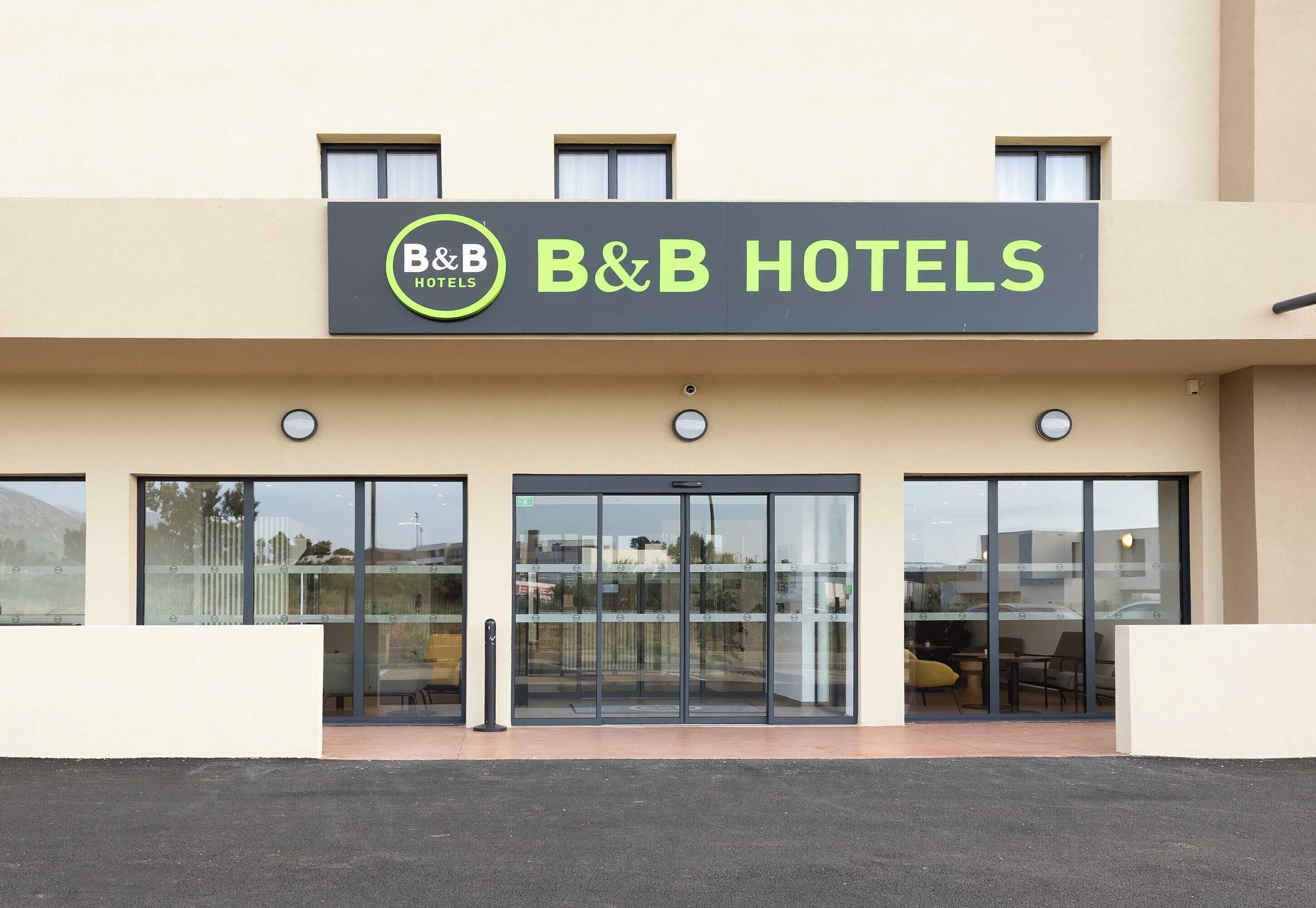 A B&B hotel with a clear entrance, large windows, and a simple facade.