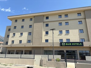Un hotel tipo bed and breakfast con fachada plana, varias ventanas y un letrero.