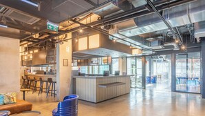 A spacious indoor area with a reception desk, seating area, and a kitchen in the background. - B&B Home La Ciotat (La Ciotat)