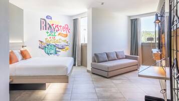 Een moderne hotelkamer met een bed, een bank en een muur met inspirerende stickers.