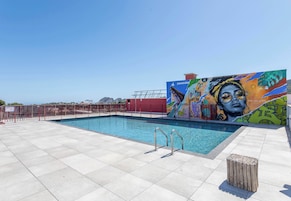 Una piscina al aire libre de temporada, sombrillas, tumbonas