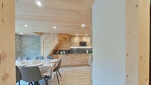 Un interior moderno con comedor, cocina y escalera.
