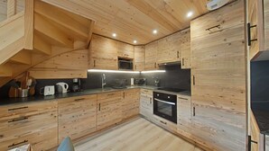Una cocina moderna con armarios de madera, un microondas, una estufa y un lavamanos.