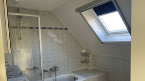 Un baño con ducha, bañera y retrete.