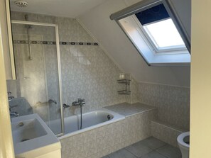 Ein Badezimmer mit Dusche, Badewanne und Toilette.