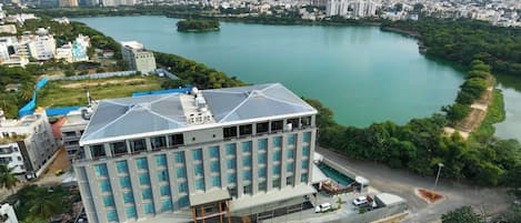 Un hôtel moderne doté d’une terrasse sur le toit, d’une grande façade vitrée et offrant une vue sur une rivière.