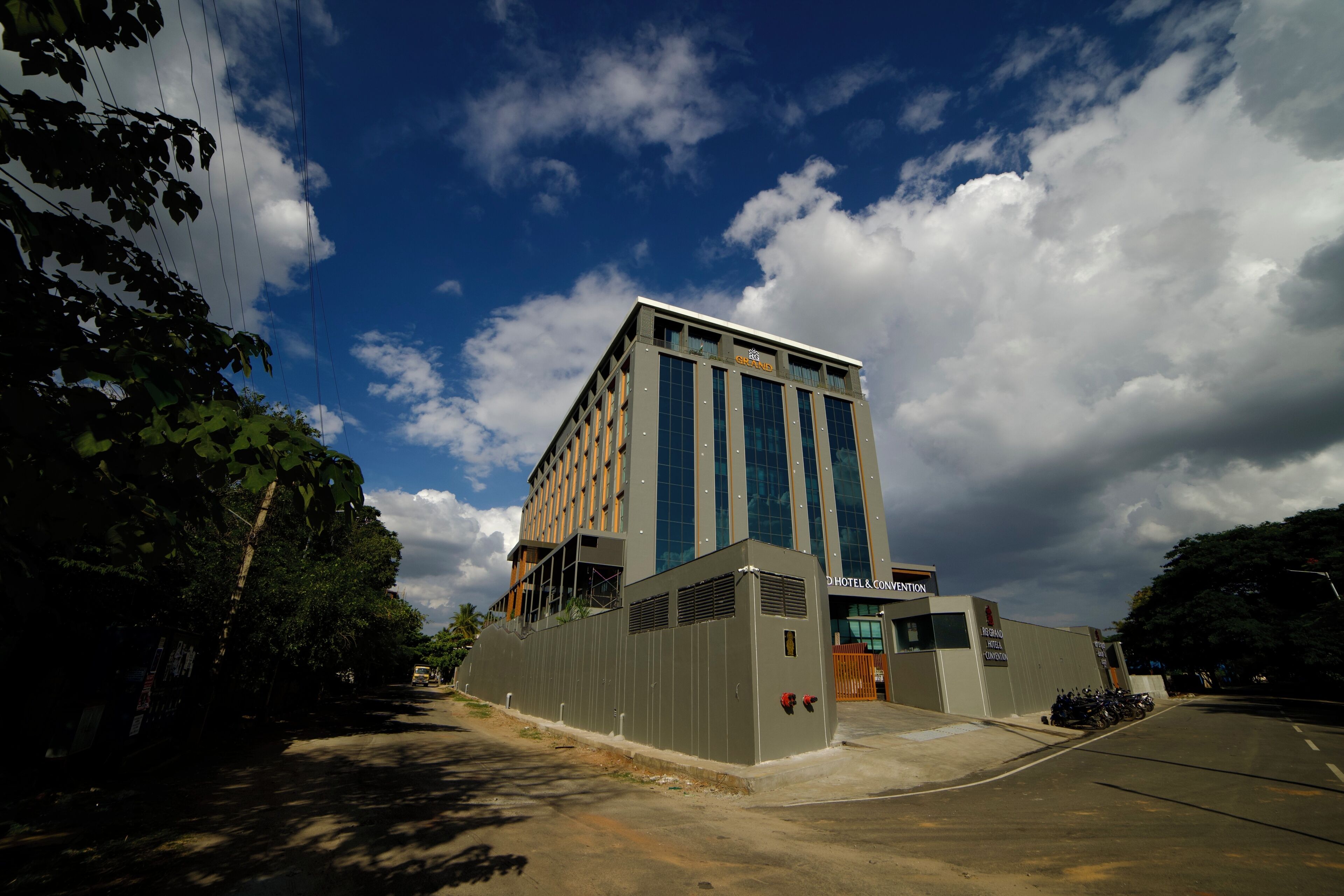 Un hôtel au design moderne, doté d’une entrée imposante, d’un espace de stationnement et offrant une vue dégagée sur le ciel.